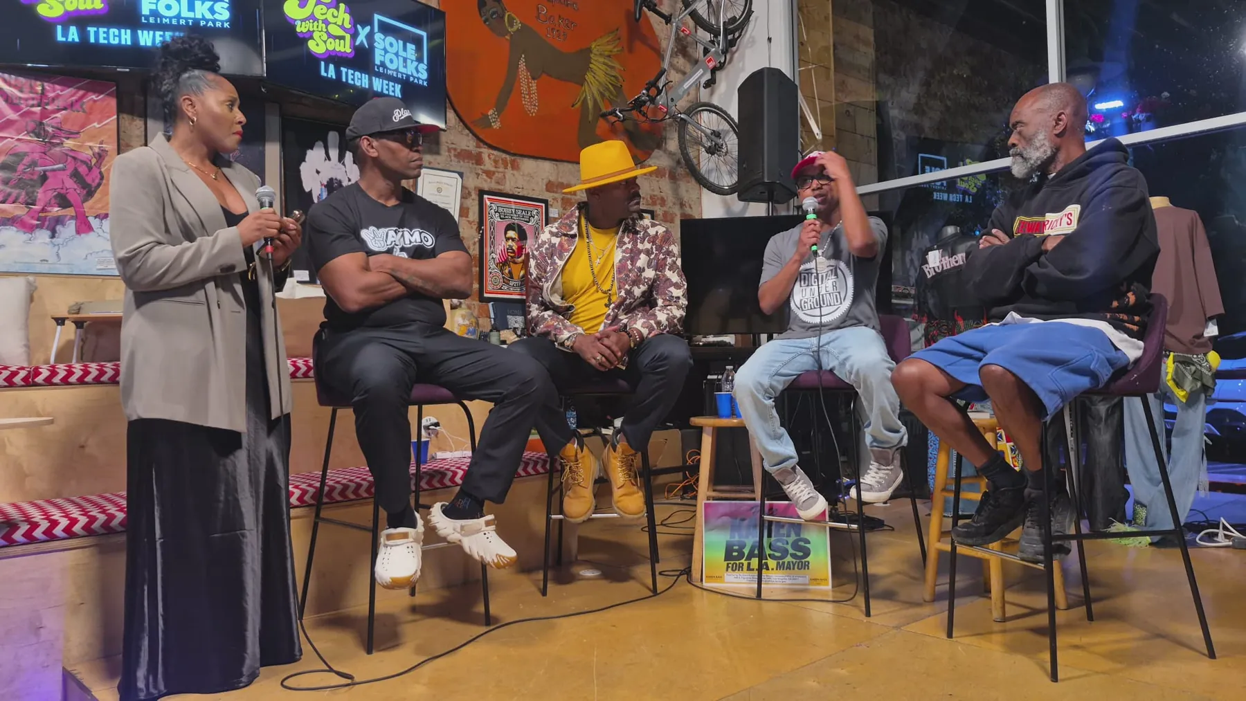 The panel in conversation on stage, with the host holding the mic